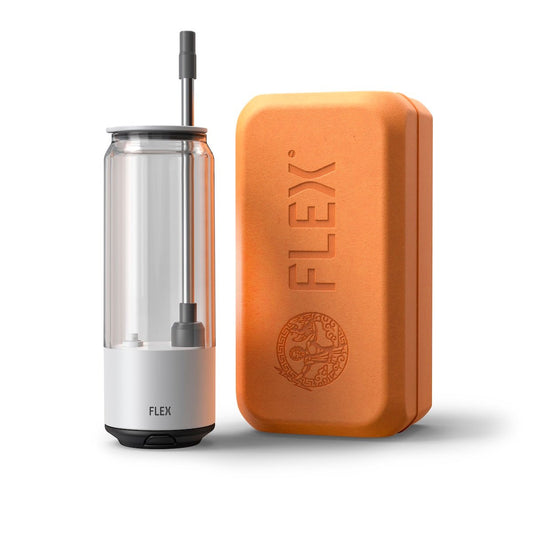 The FLEX Beverage CLEAR CAN, a sleek, transparent beverage container with a straw, stands next to its companion, the FLEX packaging. The packaging is a warm, earth-toned box embossed with the 'FLEX' logo and a detailed Greek-inspired emblem, conveying a sense of heritage and quality. This image represents the product's unboxing experience, emphasizing the premium and thoughtful packaging that complements the innovative design of the FLEX CLEAR CAN.