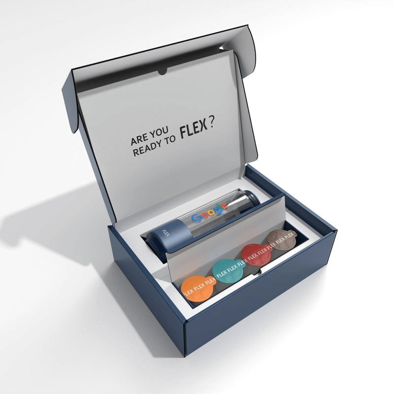 An open FLEX product box, invitingly asking "ARE YOU READY TO FLEX?" on the inside of the lid. Inside, the box is neatly organized with a FLEX CAN in blue, accompanied by a selection of colorful FLEX FUEL Pods, each labeled with different beverage options. The presentation conveys a ready-to-start experience for new users, emphasizing convenience and variety.